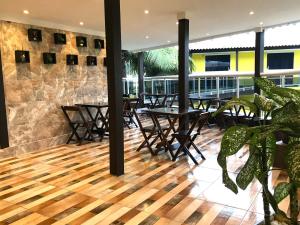 a restaurant with tables and chairs on a balcony at Pousada Gente Bonita La Mansion in Búzios