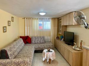 a living room with a couch and a flat screen tv at Sofia's Seaview Villa Near Airport And Beach in Artemida