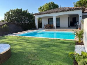 un cortile con piscina e una casa di Villa Moderne Cote d Azur a Puget-sur-Argens