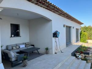 patio con divano e TV a parete di Villa Moderne Cote d Azur a Puget-sur-Argens