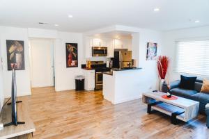 Una sala de estar con un sofá azul y una cocina. en Cozy Modern 1-Bedroom in Koreatown, Near Hollywood Attractions, en Los Ángeles