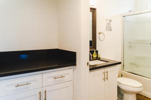 Un baño blanco con inodoro y lavabo. en Cozy Modern 1-Bedroom in Koreatown, Near Hollywood Attractions, en Los Ángeles