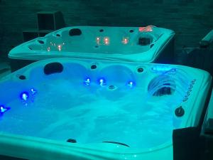 zwei Badewannen mit blauem Licht in einem Raum in der Unterkunft Le Zébresse in Combrand