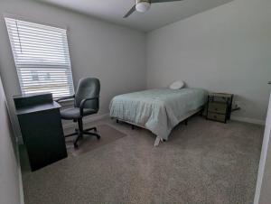 a bedroom with a bed and a desk and a chair at Vivanta Retreat in College Station