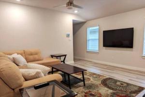 a living room with a couch and a flat screen tv at Vivanta Retreat in College Station