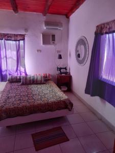 圣何塞Bungalow "El Poli 01"的一间紫色窗帘间的卧室