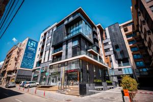 a tall building on a city street with buildings at LUST PREMIUM Apartments in Kragujevac