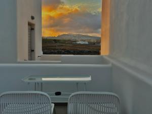 a table and two chairs in a room with a window at Montrez Studio Santorini in Mesaria