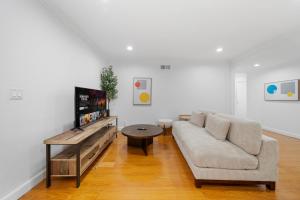 a living room with a couch and a flat screen tv at # Marbella Lane - Serene & Spacious 3BR Haven in West Covina