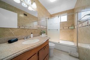 a bathroom with a sink and a shower and a toilet at # Marbella Lane - Serene & Spacious 3BR Haven in West Covina +17 photos