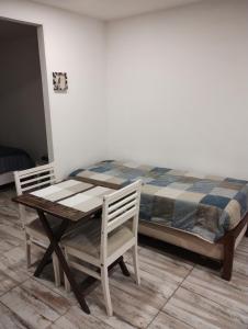 烏斯懷亞的住宿－Casa cronopio，一张桌子和两把椅子,旁边是一张床