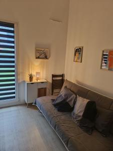 ein Wohnzimmer mit Couch und Schreibtisch in der Unterkunft Chambre à 25 min de Paris - appartement partagé in Gonesse