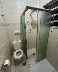 a bathroom with a toilet and a glass shower stall at Suíte independente na Vila Sônia in Sao Paulo