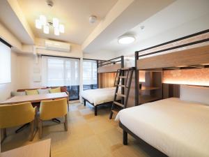 京都HIYORI Stay Kyoto Kamogawa的客房设有两张双层床和一张桌子及椅子。