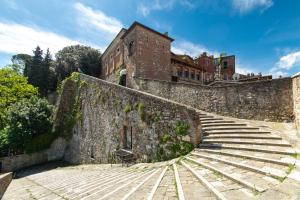 una pared de piedra con escaleras y un edificio en WellStay Perugia Downtown - Rooms, en Perugia