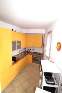 a kitchen with yellow cabinets and a sink at La Pace, il Sole, il Mare - Sanremo Casa Indipendente vista mare, posto auto privato, ampio spazio esterno attrezzato, a pochi minuti dalle spiagge in Sanremo