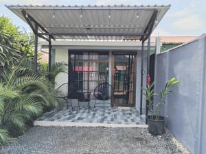 a pergola with two chairs on a patio at Kahel in Fortuna