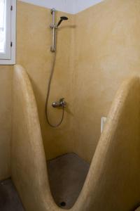 a shower with a large tub in a bathroom at Kyon Beach Suites Kythnos in Kanala