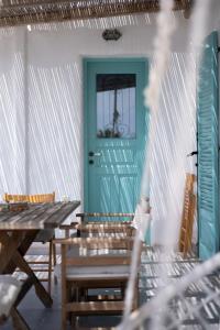 a room with a blue door and a table and chairs at Kyon Beach Suites Kythnos in Kanala +166 photos