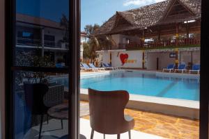 een raam met uitzicht op een zwembad bij Canary Hotel & SPA in Nungwi