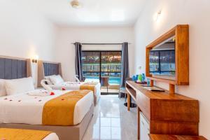 ナングウィにあるCanary Hotel & SPAのベッド2台、薄型テレビが備わるホテルルームです。