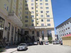 a parking lot in front of a tall building at Apartment Kievskaya 114/2 in Bishkek