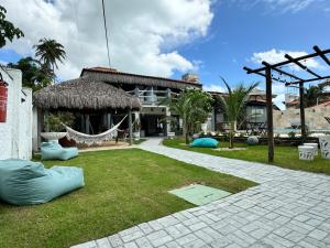 een huis met een hangmat voor een tuin bij Pousada Coconut Cumbuco in Cumbuco