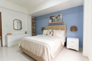 a bedroom with a large bed with blue walls at LANDA MAR BOCA CHICA in Boca Chica