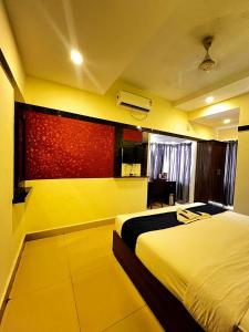 a hotel room with two beds and a window at Queens Residency - Kochi in Cochin