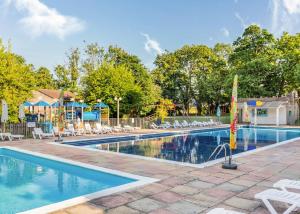 a swimming pool with chairs and a playground at Amazing Home In Newquay With Indoor Swimming Pool, Wifi And Heated Swimming Pool in Newquay