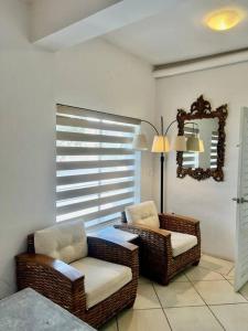 een woonkamer met 2 rieten stoelen en een raam bij Comodo apt Cerca del Malecon 5 min caminando in La Paz +5 foto's