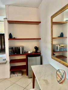 een keuken met een aanrecht, een spiegel en een tafel bij Comodo apt Cerca del Malecon 5 min caminando in La Paz