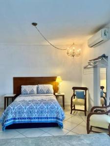 een slaapkamer met een bed en een stoel bij Comodo apt Cerca del Malecon 5 min caminando in La Paz