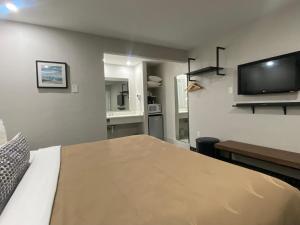 a bedroom with a bed and a flat screen tv at The Grove at Pismo Beach in Pismo Beach