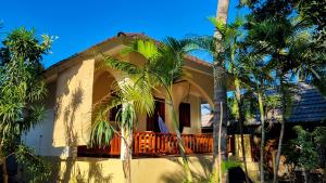 a house with palm trees in front of it at Ananda B&B in Gili Air
