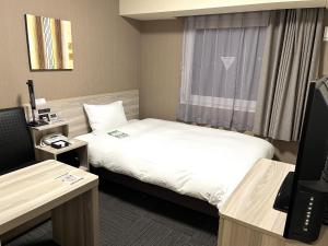 a hotel room with two beds and a television at Hotel Route Inn Takamatsu Yashima in Takamatsu