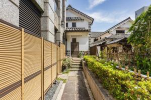 una valla de madera frente a una casa en Kurashiki Royal Art Hotel en Kurashiki