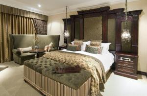 um quarto com uma cama grande e uma cadeira em Fusion Boutique Hotel em Polokwane