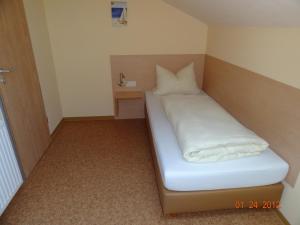 a small bed in a small room with at Pension Alram Hof in Eggenfelden +10 photos