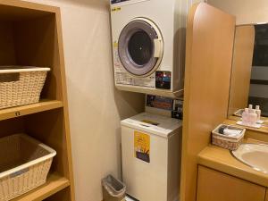 a washer and dryer in a small bathroom at Hotel Route-Inn Uozu in Uozu