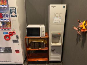 a microwave sitting on a shelf next to a refrigerator at Hotel Route-Inn Uozu in Uozu