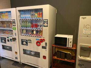 two white refrigerators with drinks and a microwave at Hotel Route-Inn Uozu in Uozu