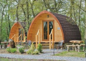 Cabaña de madera pequeña en el bosque con mesa y sillas en Paradise Lakeside Lodges en Wheldrake