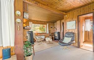 a living room with a chair and a television at Lovely Home In Hundested With Wifi in Hundested