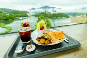 a tray with a plate of food and a drink at Zhaohong homestay in Yuchi
