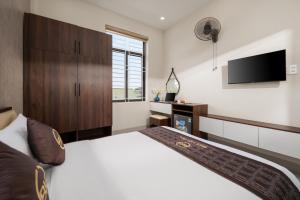 a bedroom with a large bed and a flat screen tv at BIG Hotel Huế in Hue