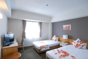 a hotel room with two beds and a television at Hotel Naha City -Kokusai Street- in Naha +46 photos