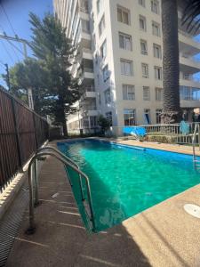 a swimming pool in front of a tall building at Vista Bahía Puerto Valparaíso - Depto entero 2 Dormitorios in Valparaíso