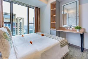 a bedroom with a large white bed with a window at Branz Apartement BSD City by Nagisa Bali in Kramat +10 photos