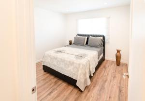 a bedroom with a bed and a wooden floor at Sleek 1-Bedroom Apartment with AC & gated Parking space in Los Angeles